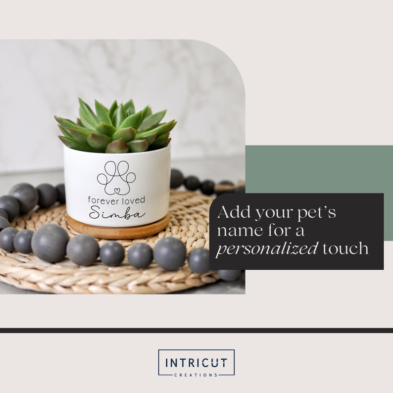 May include: A white ceramic planter with a succulent plant, featuring a paw print design and the text "forever loved Simba." The planter sits on a bamboo coaster and a woven tray with gray beads. The image includes text that says "Add your pet's name for a personalized touch."