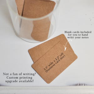 May include: Kraft paper business cards, 3.5" x 2.2", with rounded corners. The cards are displayed near a clear glass container. Text on the card reads: "Blank cards included for you to hand write your notes." and "Not a fan of writing? Custom printing upgrade available!"