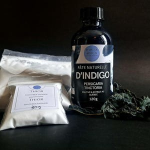 May include: An assortment of natural dye products, including a dark blue glass bottle labeled "Pâte Naturelle D'Indigo" with "Persicaria Tinctoria" and "120g" on the label. Also, a small bag labeled "Thiox Thiourea Dioxide 30g" and a larger bag of white powder.