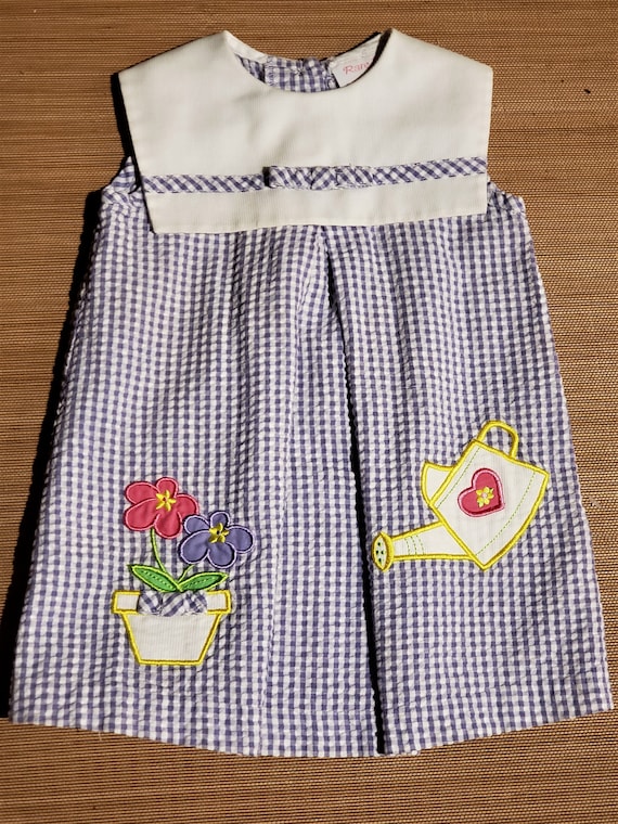 with decrotive watering pot An adorable little girl grape blue vintage gingham dress Free Shipping and a flower pot of daisy flowers.