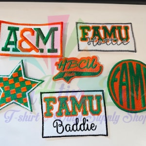 May include: A collection of embroidered patches in green, orange, and white. The patches feature text and shapes, including "A&M", "FAMU Hottie", "HBCU Made", "FAMU Baddie", and a star and circular design with "FAMU".