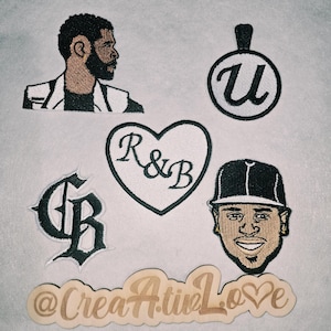 May include: A collection of embroidered patches featuring a profile of a bearded person, a circular pendant with the letter U, a heart-shaped patch with the text R&B, a gothic-style GB monogram, a portrait of a person in a cap, and a wooden sign reading @CreaAtiveLove.