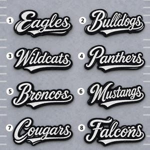 May include: Eight black and white embroidered patches featuring sports team names in a cursive script font. The names are Eagles, Bulldogs, Wildcats, Panthers, Broncos, Mustangs, Cougars, and Falcons, each numbered one through eight in white circles.