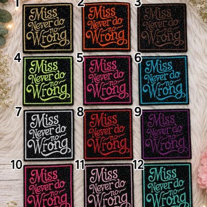 May include: Twelve square black patches with glittery surfaces, each embroidered with the text 'Miss Never do no Wrong' in a cursive font. The embroidery colors include gold, orange, brown, lime green, magenta, blue, white, red, purple, hot pink, light pink, and teal.