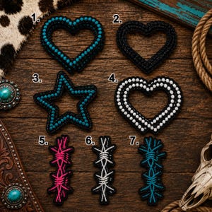 May include: A collection of seven embroidered patches labeled one through seven. Items one, three, and seven are turquoise, item two is black, item four is white, item five is pink, and item six is white. The shapes include hearts, a star, and barbed wire.