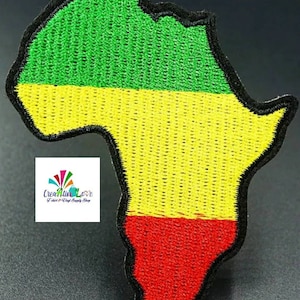 May include: An embroidered patch shaped like the continent of Africa. The patch is green, yellow, and red, resembling the Pan-African flag.