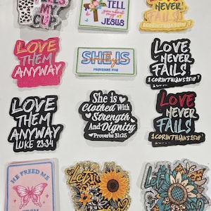 May include: A collection of twelve embroidered patches featuring various religious and inspirational phrases, including Jesus Fills My Cup, Love Never Fails, Love Them Anyway, She Is Clothed With Strength And Dignity, and He Freed Me From All My Fears.