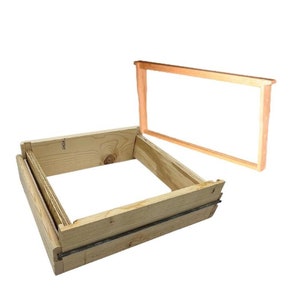 May include: A wooden beehive frame with a removable top. The frame is made of unfinished wood and has a simple design.