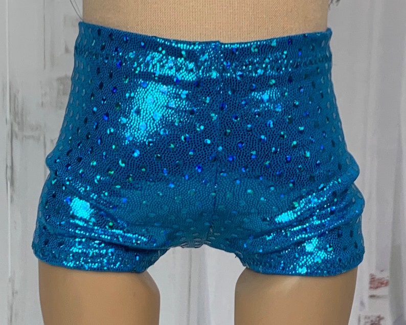 May include: Blue sparkly shorts with a dotted pattern. The shorts are made of a shiny fabric and have a high waist.