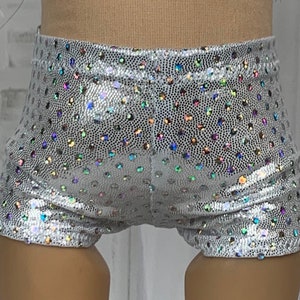 May include: Silver shorts with iridescent polka dots. The shorts are made of a shiny, stretchy fabric.