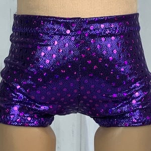 May include: Purple shorts with a shiny, iridescent finish and a polka dot pattern.