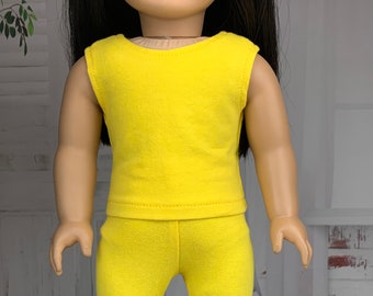 May include: A yellow sleeveless shirt and matching pants for a doll. The outfit is made of a soft, stretchy fabric.