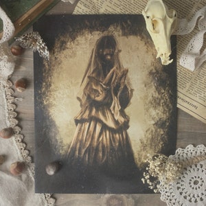 May include: A vintage-style print of a woman in a white gown, with a veil covering her face. The image is in shades of brown and white, with a distressed, aged look.