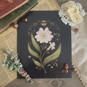 Puede incluir: Una impresión en blanco y negro de una flor estilizada con una abeja, hojas y pequeñas flores blancas. El fondo es negro.
