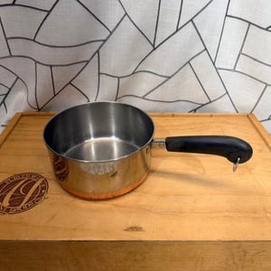 Puede incluir: Un letrero de madera hecho a mano con el texto "Welcome to our home" en un estilo manuscrito. El letrero está pintado de blanco con letras negras y un acabado envejecido, adecuado para uso en interiores o exteriores.