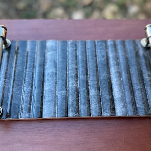 May include: A white ceramic mug with a black handle and the text "But First, Coffee" in a bold, black font. The mug is sitting on a wooden surface. The mug is approximately 4 inches tall.