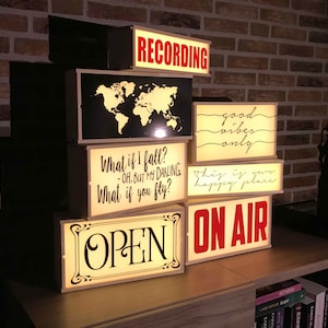 May include: A set of six light-up signs with various phrases, including "RECORDING", "What if I fall?", "good vibes only", "this is your happy place", "OPEN", and "ON AIR".