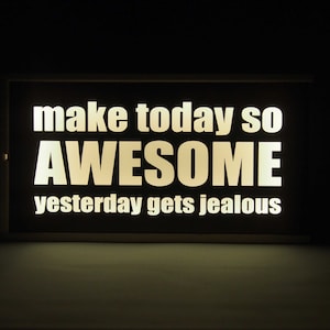 Op de afbeelding: Een zwart bord met witte tekst die zegt "make today so AWESOME yesterday gets jealous".