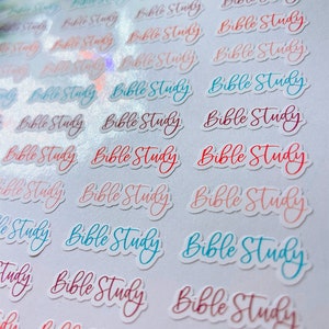 May include: A sheet of small stickers with the words "Bible Study" in a cursive font. The stickers are in various colors, including red, pink, and blue. The stickers are arranged in rows and columns.