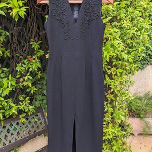 Handmade vintage black dress from the 70s France. Without sleeves. Tight, low-cut, slits with embroidery