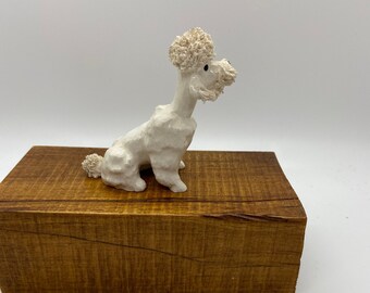 Caniche blanco con porcelana de lengua roja o figura cerámica