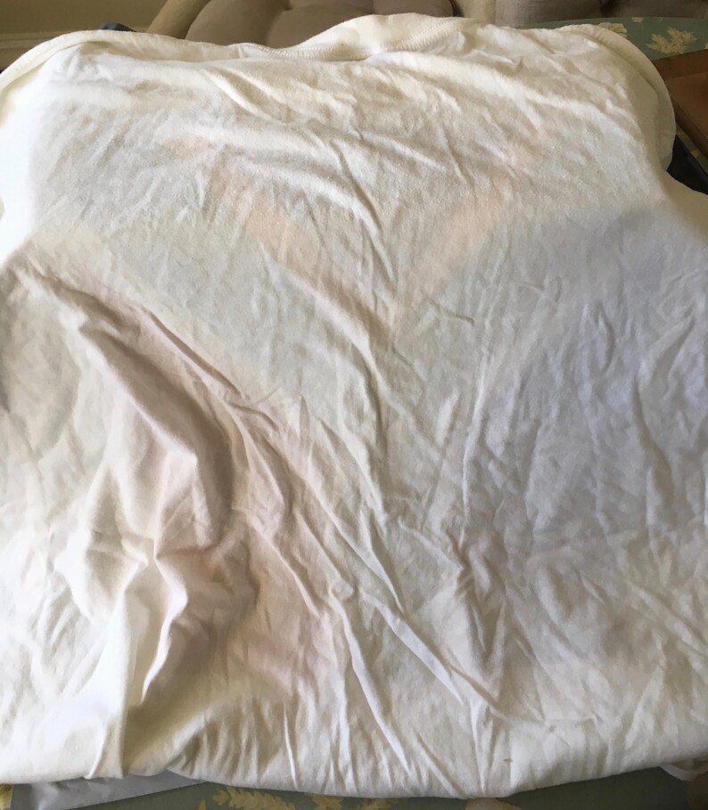 Pode incluir: Uma camiseta branca de algod&atilde;o com uma superf&iacute;cie lisa e sem rugas.