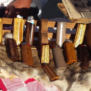 Puede incluir: Una colecci&oacute;n de estuches para encendedores de madera con varios patrones de veta de madera y detalles plateados. Algunos estuches tienen una ventana de pl&aacute;stico transparente para ver el encendedor en el interior.