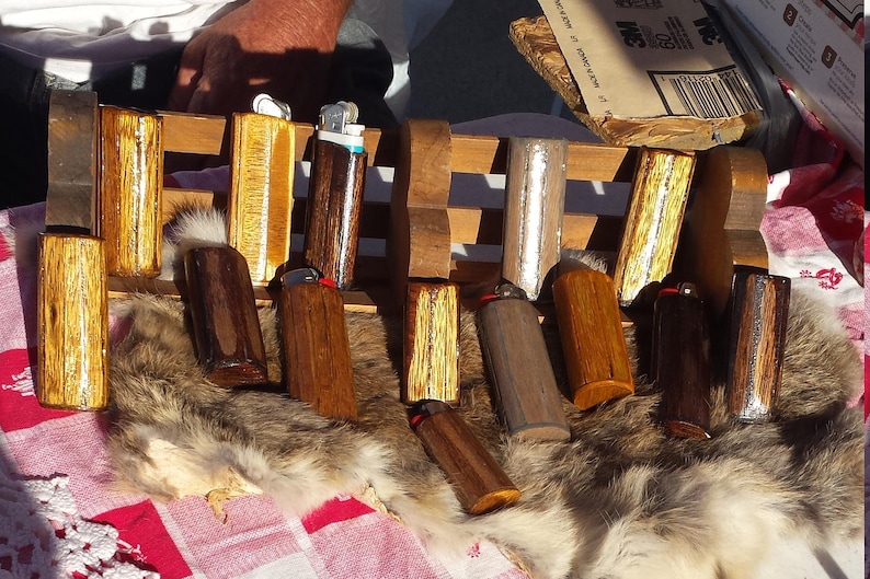 Puede incluir: Una colecci&oacute;n de estuches para encendedores de madera con varios patrones de veta de madera y detalles plateados. Algunos estuches tienen una ventana de pl&aacute;stico transparente para ver el encendedor en el interior.