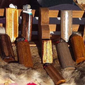 Puede incluir: Una colecci&oacute;n de encendedores de madera con varios patrones de veta de madera y acabados. Algunos encendedores tienen un acabado met&aacute;lico plateado o dorado. Los encendedores est&aacute;n dispuestos sobre una superficie de piel.