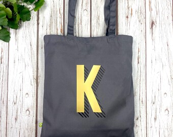 Tasche aus Bio-Baumwolle. Grauer Shopper mit Wunschbuchstaben in Regenbogenfarbe.