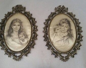 May include: Two oval framed pictures with ornate silver frames. Each picture features a black and white drawing of a mother and child.