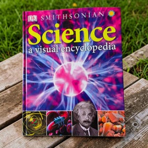 May include: A hardcover book titled DK Smithsonian Science A Visual Encyclopedia. The cover features a vibrant purple and blue plasma ball graphic, a portrait of Albert Einstein, and smaller scientific images of atoms and crystals.