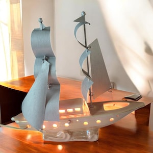 May include: A set of three ceramic canisters with lids. The canisters are white with a blue floral pattern. The largest canister is 8 inches tall, the medium is 7 inches, and the smallest is 6 inches.