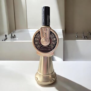 May include: A gold-colored decorative object resembling a ship's engine order telegraph. It has a black top and a circular dial with the words "Dead Slow", "Slow", "Half", and "Full". The base is a flared shape.