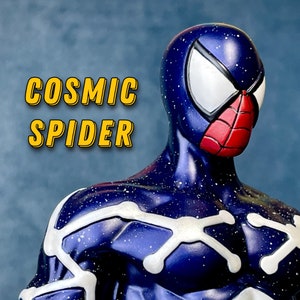 Puede incluir: Una figura de Spider-Man c&oacute;smico azul y blanco con un s&iacute;mbolo de ara&ntilde;a rojo en la m&aacute;scara. La figura tiene un patr&oacute;n de cielo estrellado en el traje.