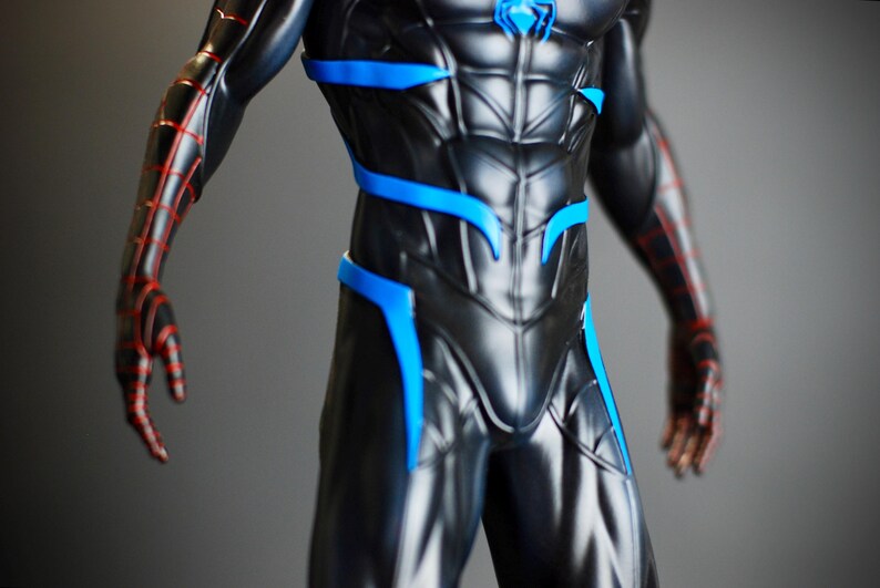 May include: A black and blue superhero costume with red accents. The suit features a detailed design with blue highlights and red web-like patterns on the arms. A blue emblem is on the chest.