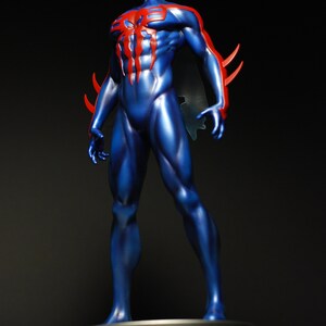May include: A blue and red action figure of a superhero with a spider design on the chest. The figure is standing on a black base.