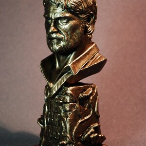 Pu&ograve; includere: Un busto in bronzo di un uomo con la barba e i capelli corti. Il busto &egrave; su una base con le parole "The Last of Us" incise su di essa. La base &egrave; decorata con viti e foglie. Il busto &egrave; etichettato "Custom Joel Bust".
