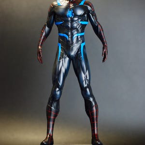 May include: A black and blue superhero figurine with red accents. The figure is standing on a round, metallic base. The superhero suit features a spider emblem on the chest and blue highlights. The figure's mask has a unique design.