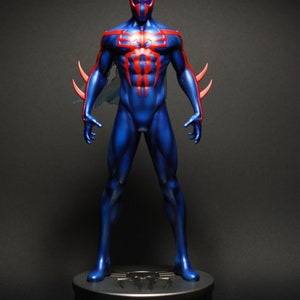 May include: A blue and red action figure of Spider-Man in a standing pose. The figure is on a black base with a silver spider logo.