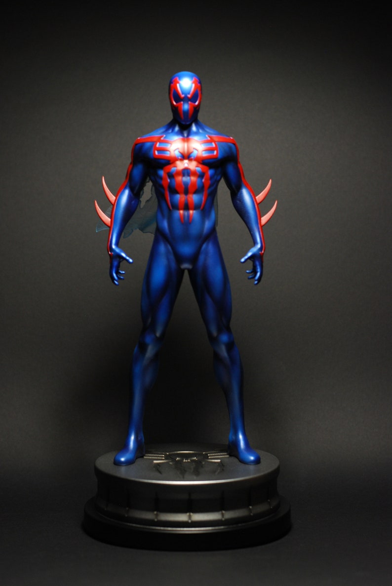 May include: A blue and red action figure of Spider-Man in a standing pose. The figure is on a black base with a silver spider logo.