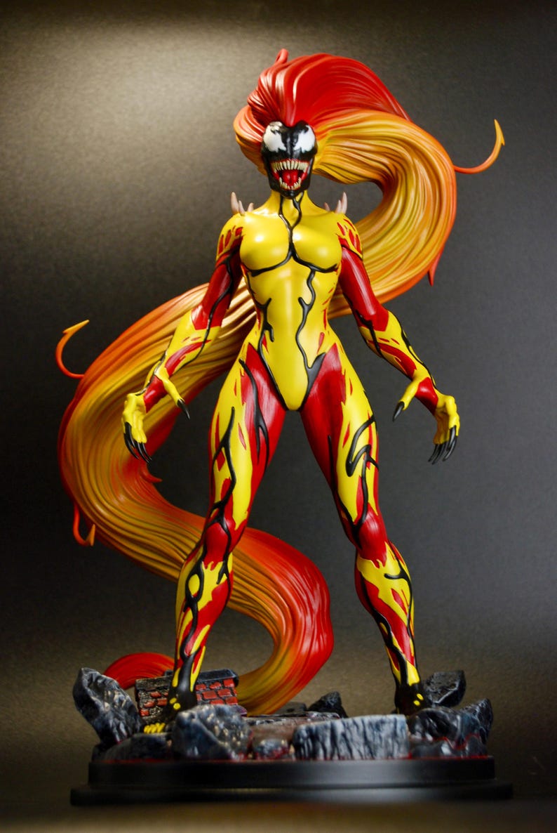 May include: A detailed figurine of a female character with a yellow and red color scheme. The figure has long, flowing hair in shades of red and yellow. The character is posed on a rocky base, with a menacing expression and clawed hands.