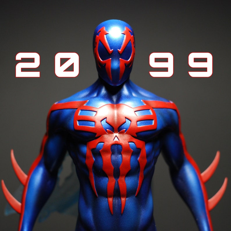 May include: A blue and red superhero action figure with a spider web design on the chest. The figure has a mask with a red spider design. The figure is posed with arms outstretched and a determined expression.