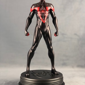 May include: Black and red Spider-Man action figure with a black base. The figure is standing with its arms outstretched and has a red spider symbol on its chest.
