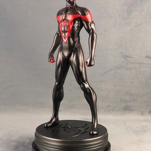 May include: Black and red Spider-Man action figure with a black base. The figure is posed with its arms out and its fists clenched. The figure is standing on a black base with a spider web design.
