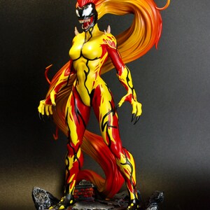 May include: A detailed figurine of a female character with a fiery appearance. The figure is predominantly yellow and red, with a flowing hairstyle that transitions from red to yellow. The character has sharp claws and stands on a rocky base.