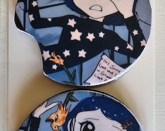 May include: Two car coasters featuring a cartoon character with blue hair and a black top with white stars. The coasters have a blue background with a floral design and text that reads "Hey Jonesy, Look what I..."