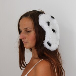 A pretty girl modelling Dalmatian dog ears, kidney bean shaped white faux fur with small black spots. Sewn onto a thin black hairband.