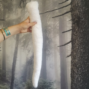 May include: A long, white, fluffy faux fur tail with a loop at the top for attaching.