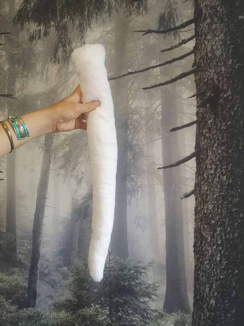 May include: A long, white, fluffy faux fur tail with a loop at the top for attaching.